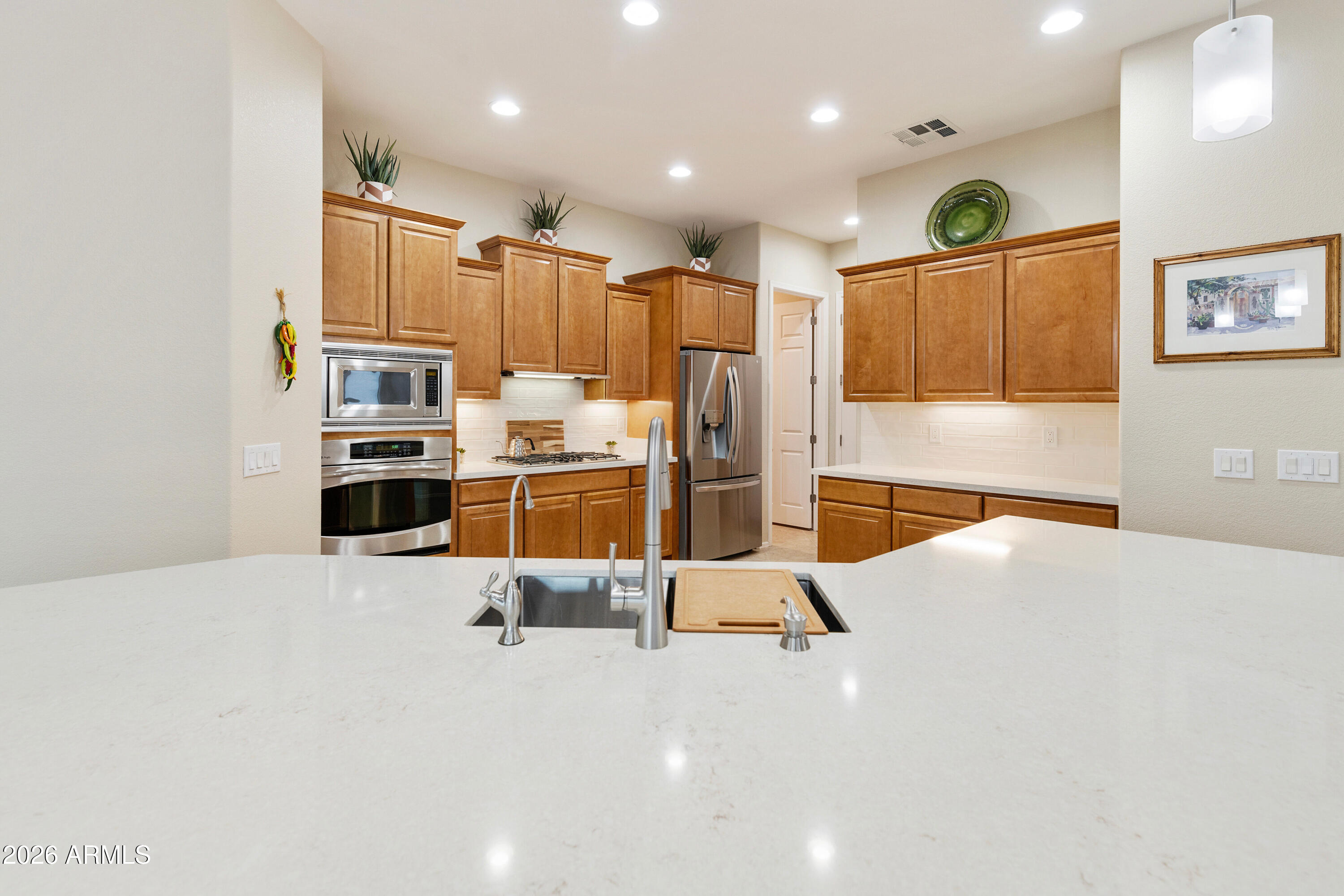 5291 South Sugarberry Court Gilbert, AZ 85298 - Photo 14 of 67 a large kitchen with stainless steel appliances kitchen island sink refrigerator and microwave