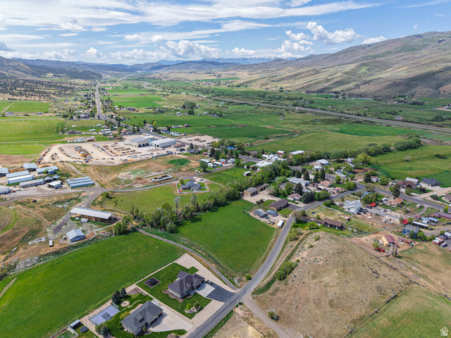 94 Spring Canyon Road Coalville, UT 84017 - Photo 23 of 50 Aerial perspective showcasing a valley setting with residential properties, agricultural fields, and distant mountainous terrain