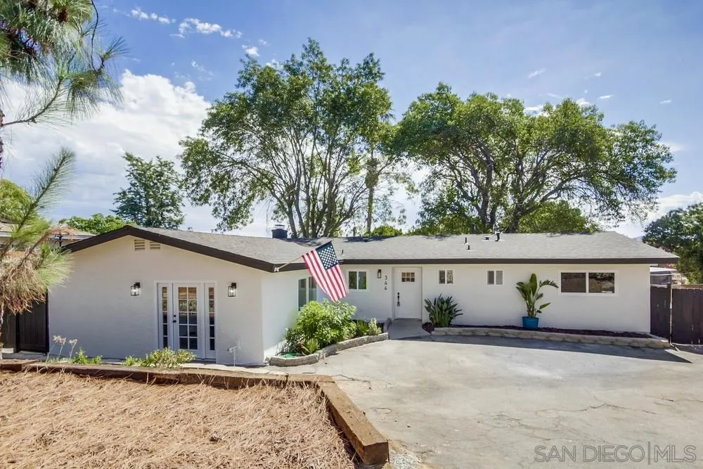 344 Mountain View Road El Cajon, CA 92021 - Photo 1 of 38 a view of a white house with a yard and a large tree