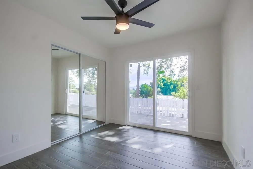 344 Mountain View Road El Cajon, CA 92021 - Photo 18 of 38 an empty room with wooden floor fan and windows
