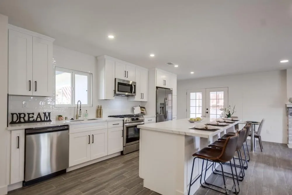 344 Mountain View Road El Cajon, CA 92021 - Photo 5 of 38 a kitchen with stainless steel appliances kitchen island granite countertop a stove a sink a dining table and chairs