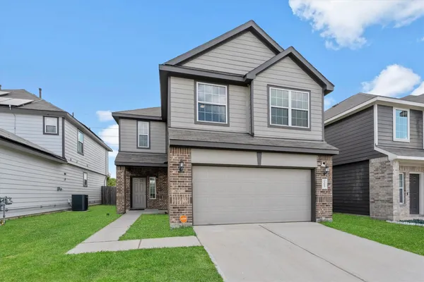 a front view of a house with a yard and garage
