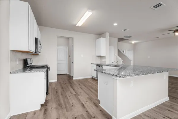 a kitchen with kitchen island a sink stainless steel appliances and cabinets