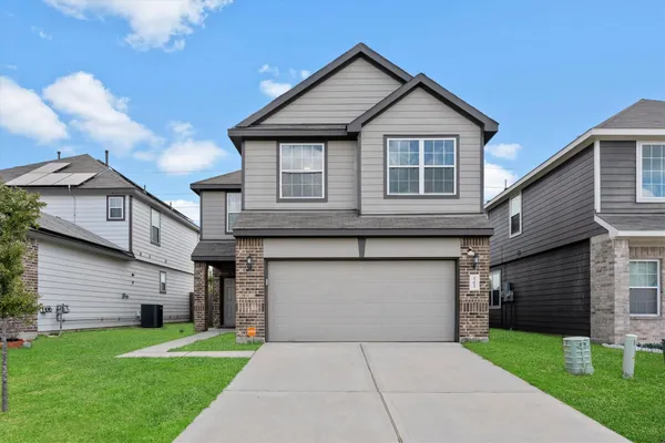 a front view of a house with a yard and garage