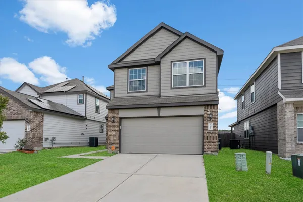 a front view of a house with a yard and garage