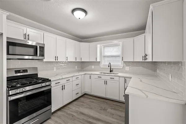 a kitchen with a sink stove and microwave