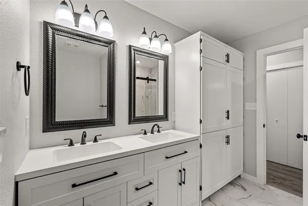 a bathroom with double vanity sink and mirror