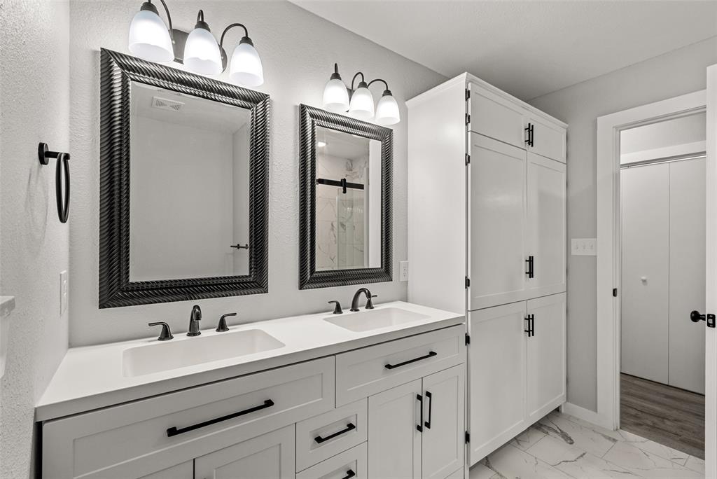 1506 West Main Street Denison, TX 75020 - Photo 21 of 38 a bathroom with double vanity sink and mirror