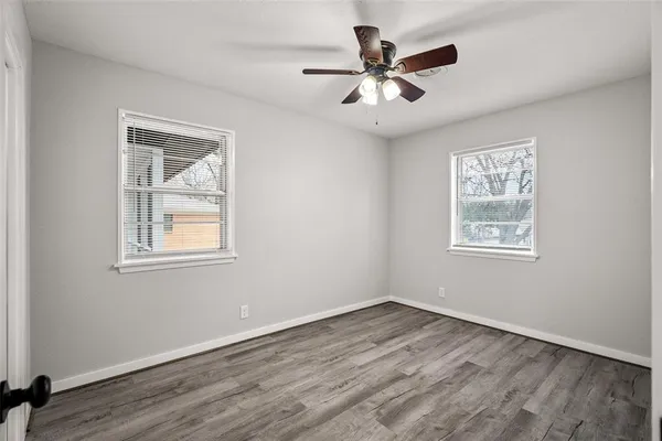 a view of a big room with wooden floor and windows