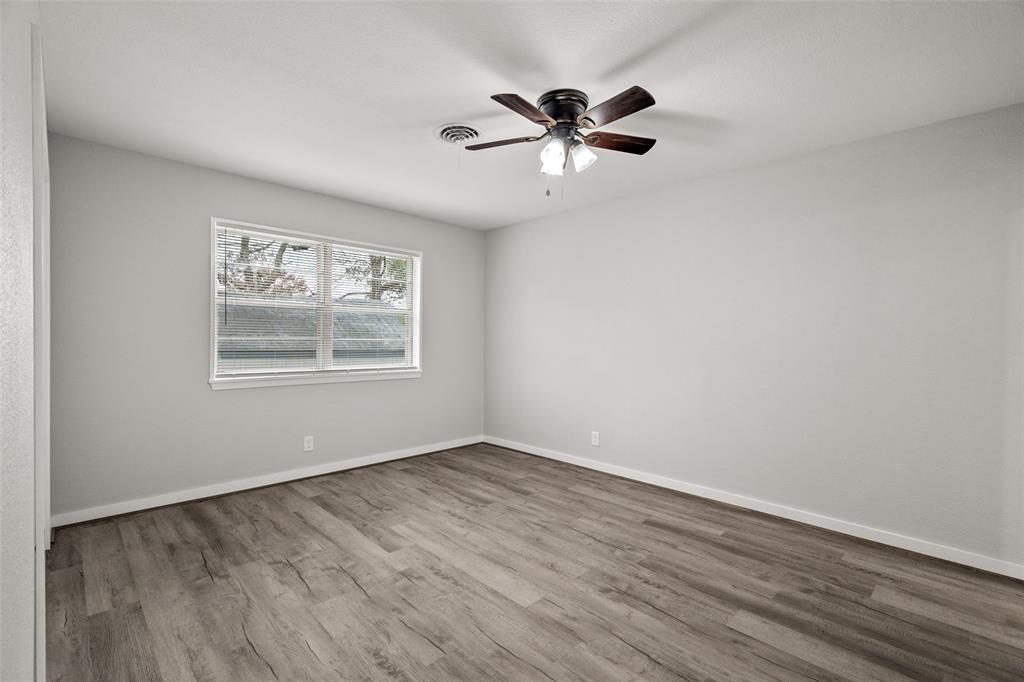 1506 West Main Street Denison, TX 75020 - Photo 24 of 38 a view of an empty room with wooden floor and a window