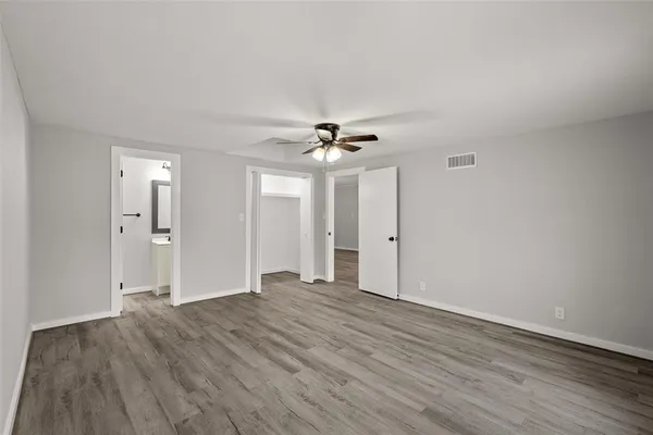 a view of a livingroom with a ceiling fan window and wooden floor