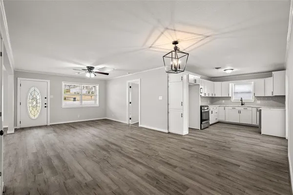a view of a kitchen with wooden floors and appliances