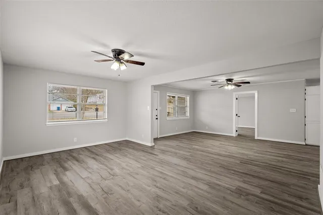 an empty room with fan and windows