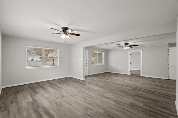 an empty room with fan and windows