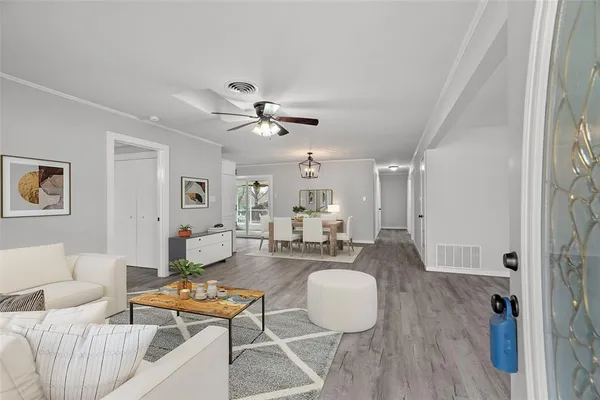 a living room with furniture and a wooden floor