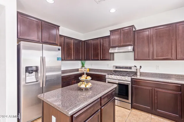 a kitchen with stainless steel appliances granite countertop a stove refrigerator sink and cabinets