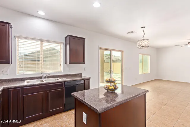 a kitchen with a sink a window and chairs