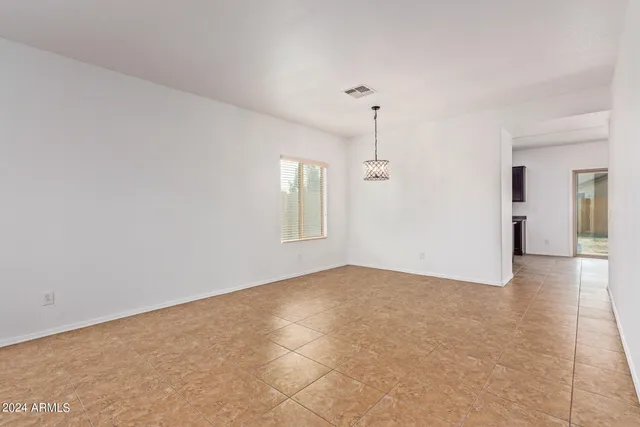 a view of a big room with windows and chandelier fan