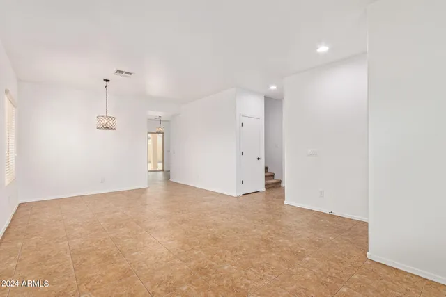 an empty room with a ceiling fan and window