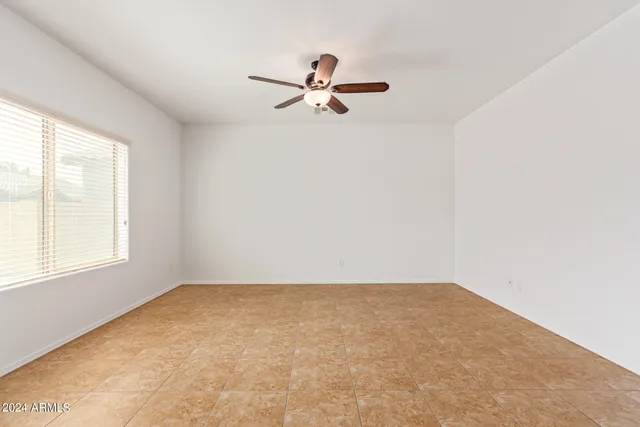 an empty room with a window and a fan