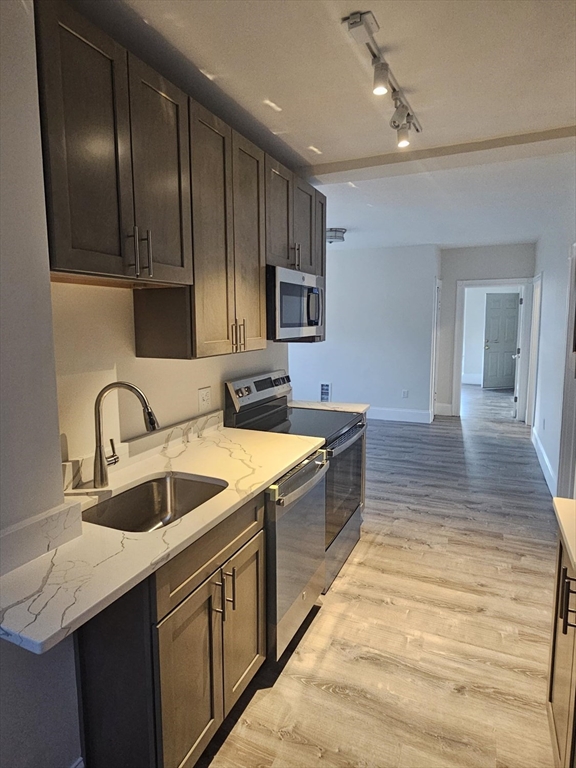 a kitchen with stainless steel appliances granite countertop a sink stove and cabinets