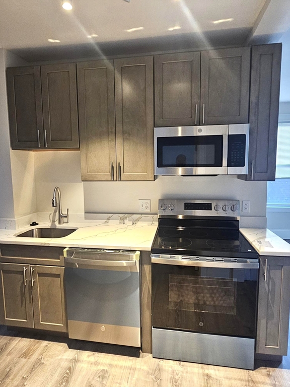 323 Chatham Street, Unit 3 Lynn, MA 01902 - Photo 2 of 13 a kitchen with granite countertop a stove and a sink