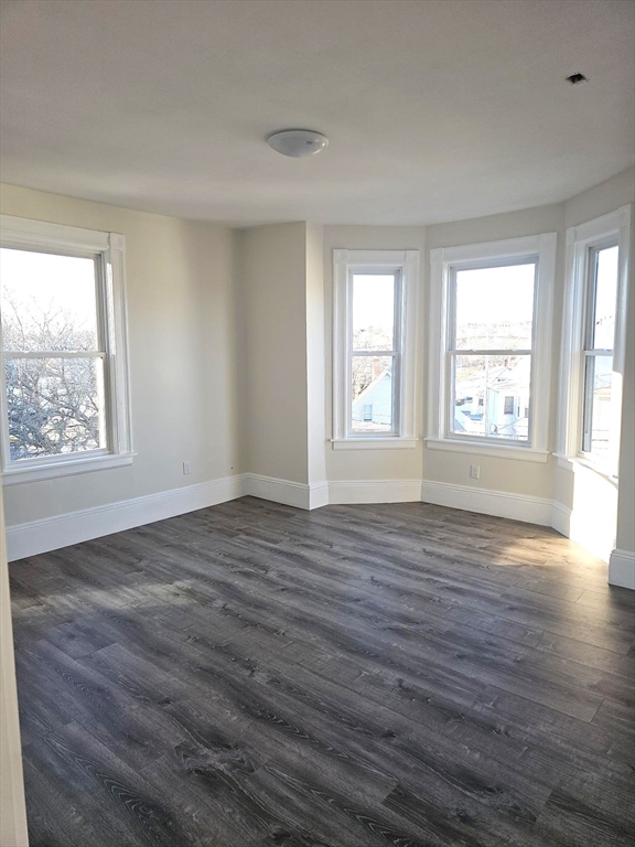 323 Chatham Street, Unit 3 Lynn, MA 01902 - Photo 10 of 13 an empty room with wooden floor and windows