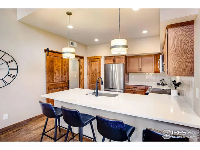 a kitchen with stainless steel appliances kitchen island granite countertop a sink a stove a dining table and chairs