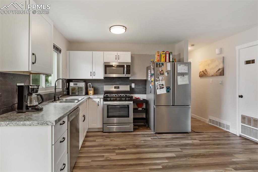 509 Inca Drive Colorado Springs, CO 80911 - Photo 14 of 30 a kitchen with stainless steel appliances granite countertop a stove top oven a sink and a refrigerator