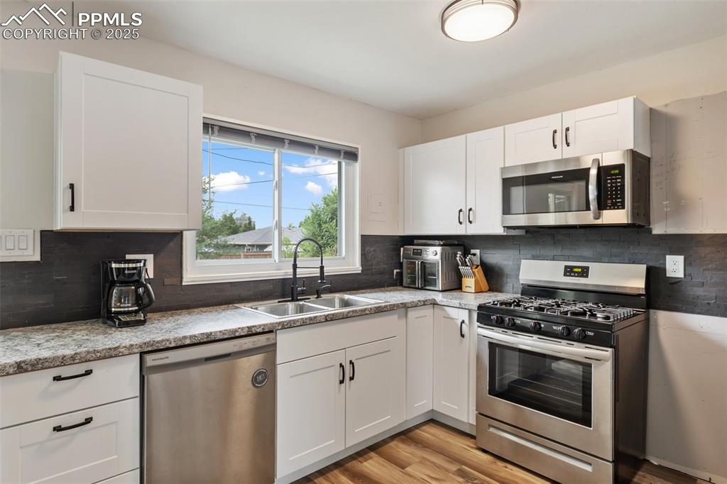 509 Inca Drive Colorado Springs, CO 80911 - Photo 16 of 30 a kitchen with granite countertop a sink cabinets stainless steel appliances and a window