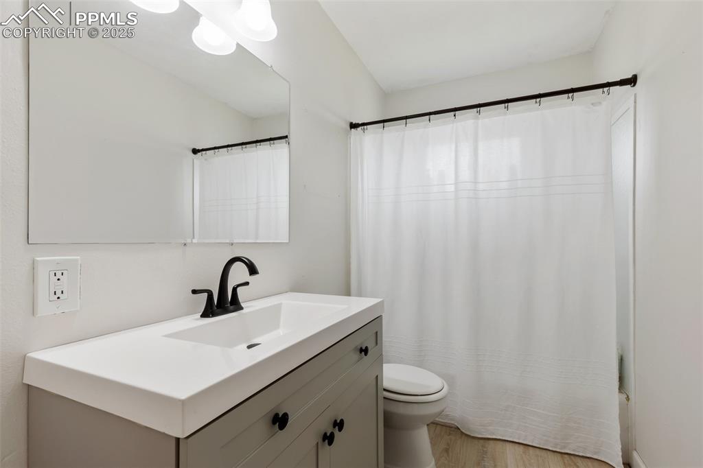 509 Inca Drive Colorado Springs, CO 80911 - Photo 21 of 30 a bathroom with a sink a toilet a mirror and shower curtain
