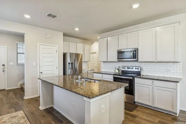 a kitchen with stainless steel appliances granite countertop a sink stove and refrigerator