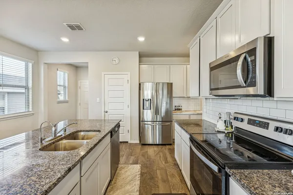 a kitchen with stainless steel appliances granite countertop a sink stove and refrigerator