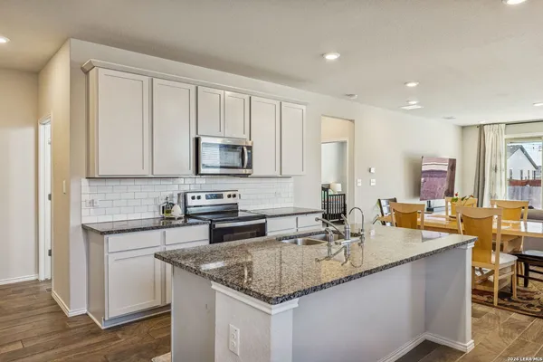 a kitchen with stainless steel appliances granite countertop a sink stove and cabinets