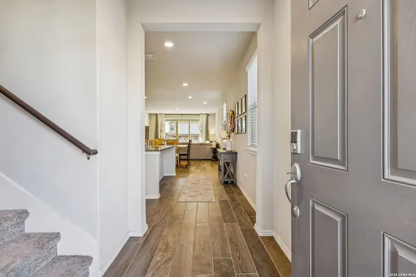 a view of a hallway with wooden floor and furniture