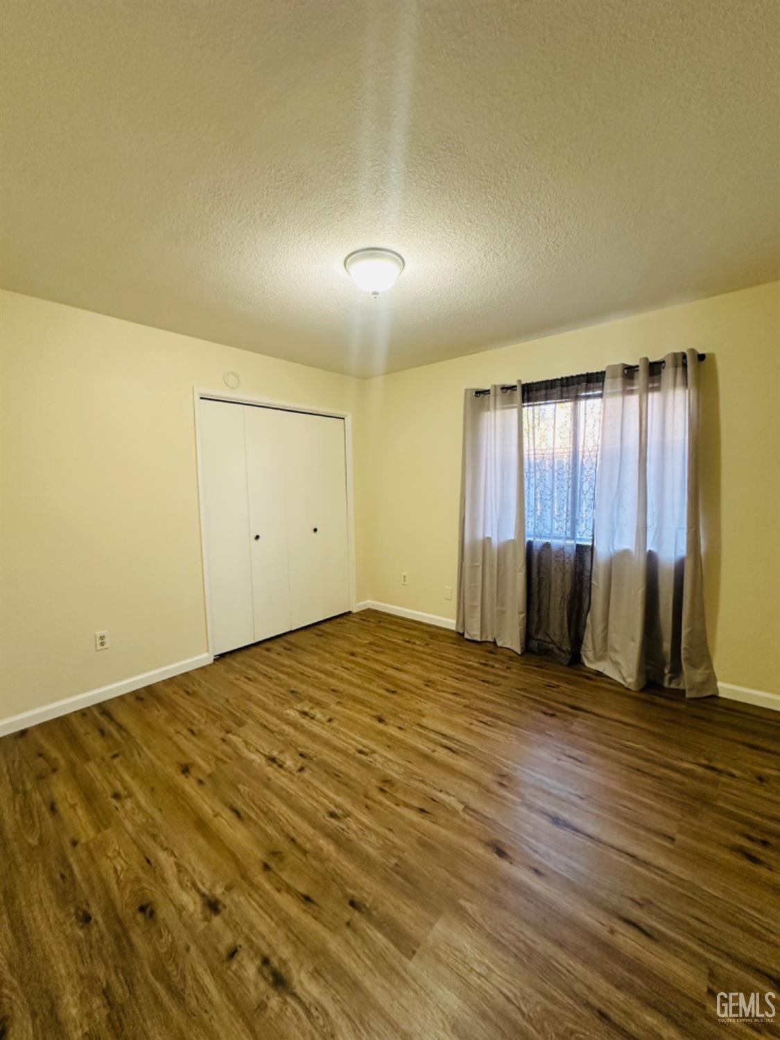 Undisclosed Address Bakersfield, CA 93309 - Photo 17 of 32 a view of an empty room with wooden floor and a window