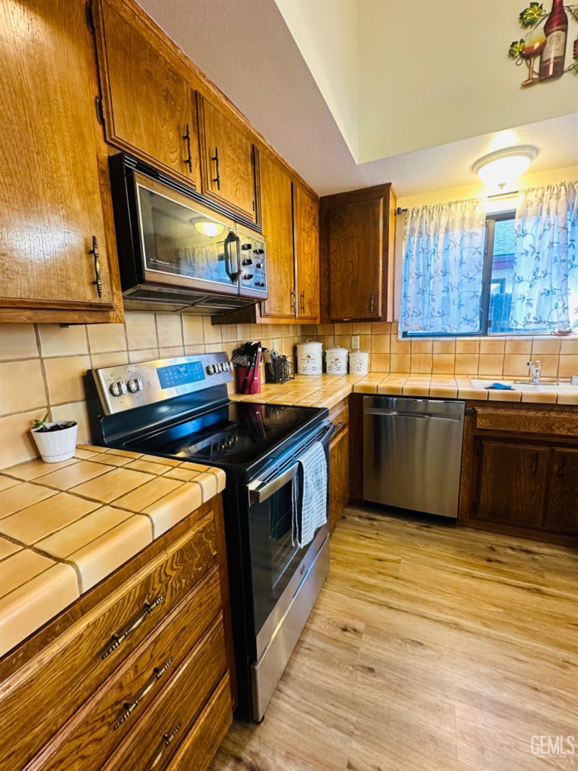 Undisclosed Address Bakersfield, CA 93309 - Photo 8 of 32 a kitchen with stainless steel appliances a sink cabinets and wooden floor
