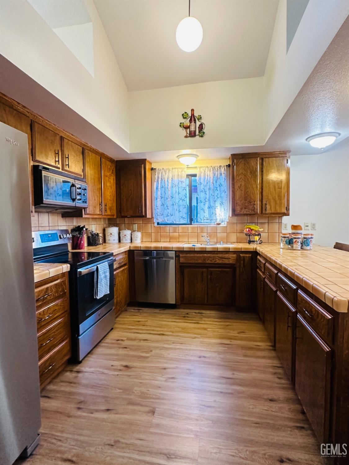 Undisclosed Address Bakersfield, CA 93309 - Photo 10 of 32 a kitchen with stainless steel appliances and a wooden cabinets