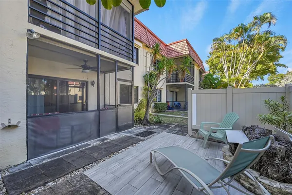 a view of a chair and table in backyard of the house