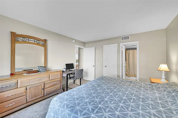 a bedroom with a bed and a large mirror on dresser