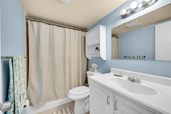 a bathroom with a sink a toilet and shower curtain