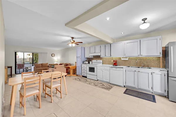 a kitchen with white cabinets and chairs