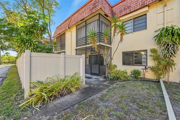 front view of a house with potted plants and a white door