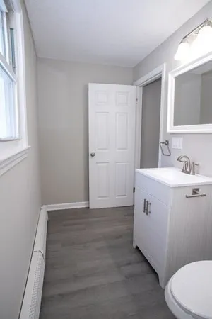 a bathroom with a granite countertop sink a toilet and shower