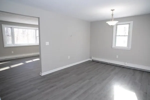 an empty room with windows and fireplace