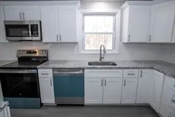 a kitchen with granite countertop white cabinets and a stove