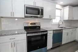 a kitchen with stainless steel appliances granite countertop white cabinets granite counter tops and a wooden floors