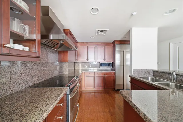 a kitchen with stainless steel appliances granite countertop a sink and a stove