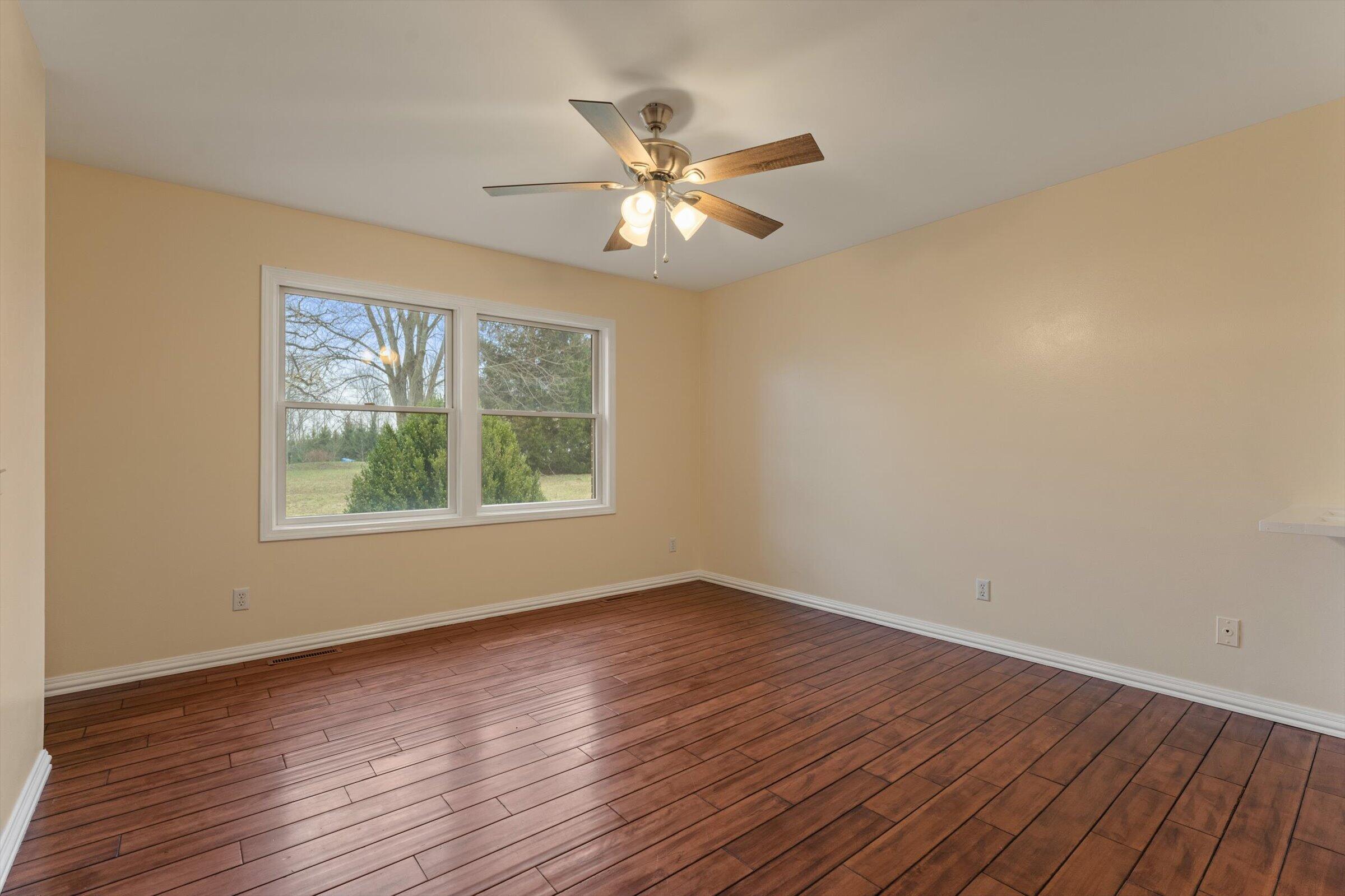 7692 North Emery Road Rolling Prairie, IN 46371 - Photo 20 of 69 a view of an empty room with wooden floor and a window