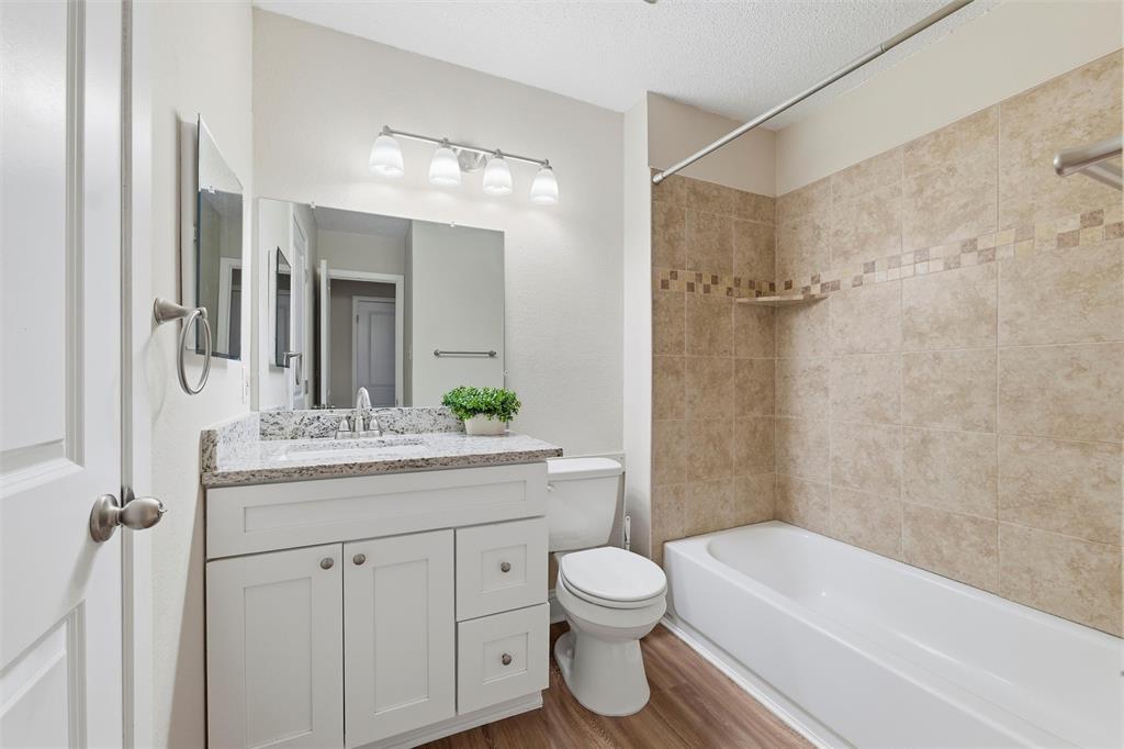 112 Churchill Lane Euless, TX 76039 - Photo 23 of 33 a bathroom with a granite countertop sink a toilet and shower